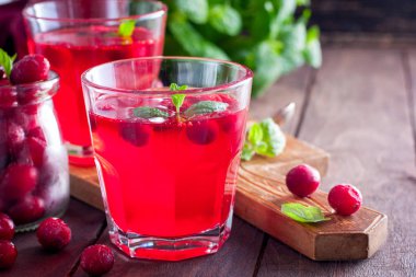 Kopya alanı, ahşap bir masaya cam bardak kızılcık ferahlatıcı vitamin içeceği gelen yatay dondurulmuş