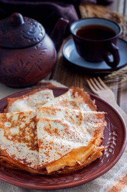 Ahşap bir masa, seçici odak üzerinde çay ile kil tabakta ince File krep