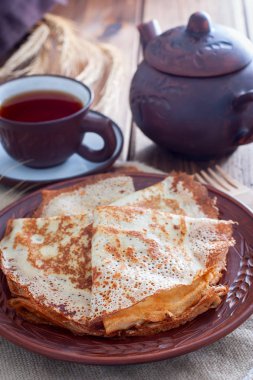 Ahşap bir masa, seçici odak üzerinde çay ile kil tabakta ince File krep