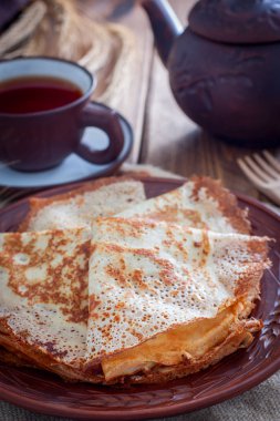 Ahşap bir masa, seçici odak üzerinde çay ile kil tabakta ince File krep