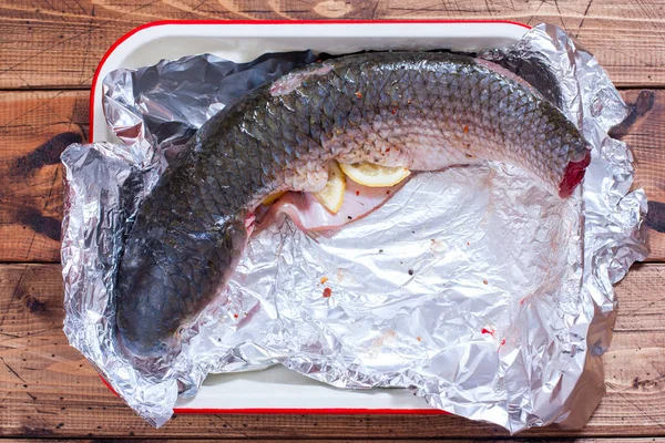 The process of cooking baked kevali in foil, top view, selective focus