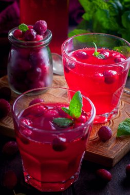 Ahşap bir masa, seçici odak üzerinde cam bardak kızılcık vitamin içeceği yenileniyor