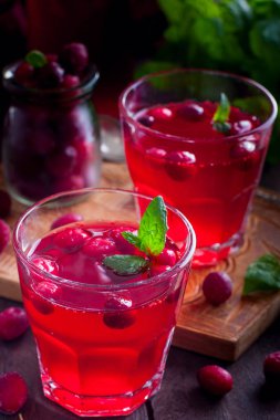 Ahşap bir masa, seçici odak üzerinde cam bardak kızılcık vitamin içeceği yenileniyor