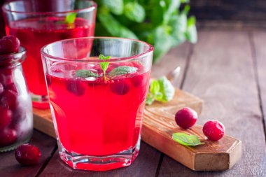 Kopya alanı, ahşap bir masaya cam bardak kızılcık ferahlatıcı vitamin içeceği gelen yatay dondurulmuş