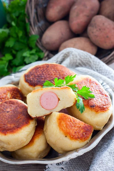 Sausage in potato dough on a metal dish, selective focus — Stock Photo, Image