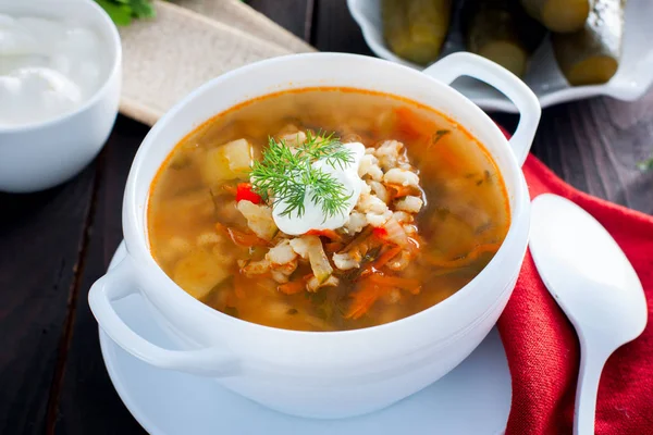 Soup with pickled cucumbers and pearl barley - rassolnik on a wooden background,horizontal — Stock Photo, Image