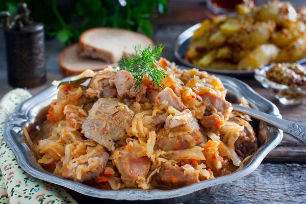 Gestoofde kool met vlees van kalkoenen dij op een houten tafel, horizontale — Stockfoto