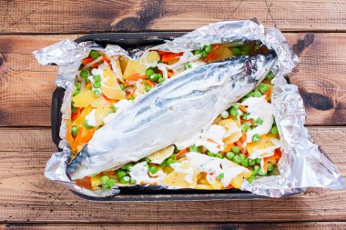 Sebzeli - patates, havuç, soğan, yeşil bezelye pişirme, en iyi görünüm için hazırlanan bir tabak içinde ham uskumru