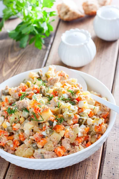 Ensalada rusa en español con atún enlatado en un plato blanco sobre una mesa de madera, horizontal — Foto de Stock