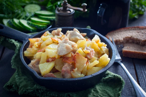 Patatas fritas con pollo en una sartén negra de hierro fundido, horizontal — Foto de Stock