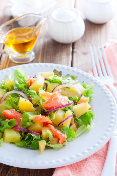 Salade de pommes de terre au saumon sur une assiette blanche, mise au point sélective — Photo