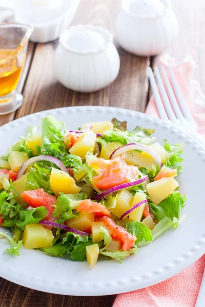 Salade de pommes de terre au saumon sur une assiette blanche, mise au point sélective — Photo