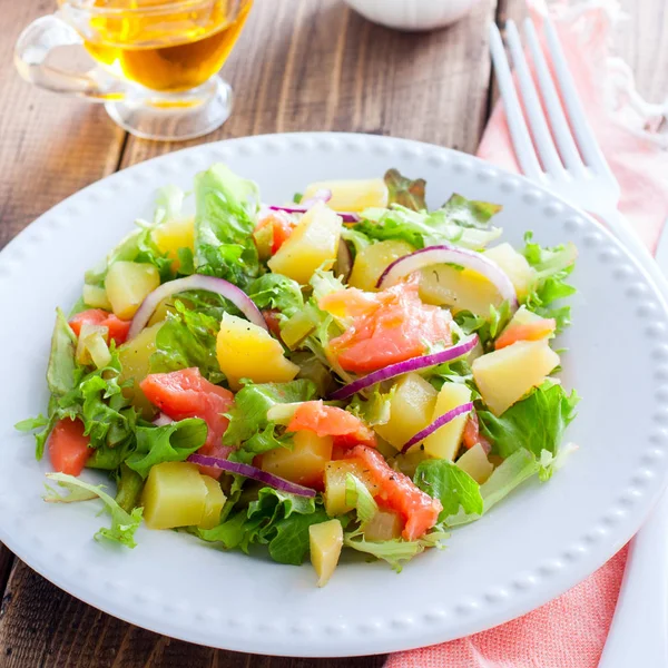 Salade de pommes de terre au saumon sur une assiette blanche, mise au point sélective — Photo