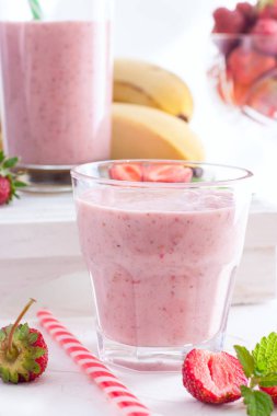 Smoothies Çilek ve muz beyaz bir tablo seçici odak cam bardaklarda