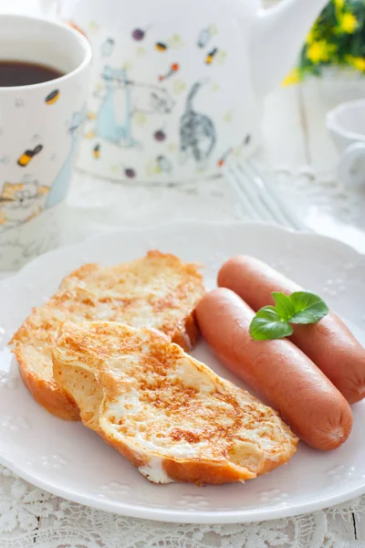 Ontbijt met worstjes en wit brood, gebakken in eieren en melk, selectieve focus — Stockfoto