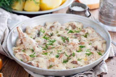 Orman mantarları ekşi krema sosuyla ahşap bir masada, yatay olarak.