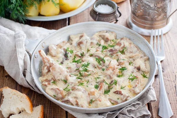 Boschampignons in zure roomsaus op een pan op een houten tafel, horizontaal — Stockfoto