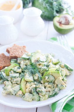 Salata salatalık, yumurta ve beyaz bir tabak, seçici odak üzerinde avokado ile