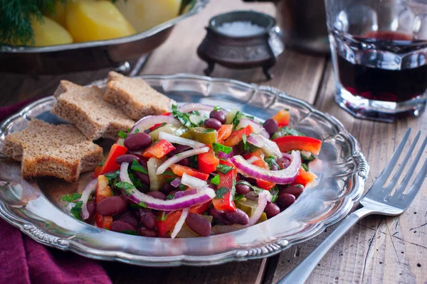 Вегетарианский салат с красной фасолью и маринованными огурцами на металлической пластине, горизонтальный — стоковое фото