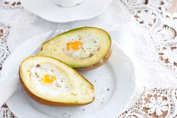 Gebacken mit Avocado-Ei zum Frühstück auf einem weißen Teller, horizontal — Stockfoto