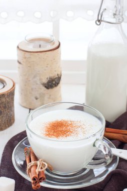 Tarçın ve şeker ile cam bir fincan ev yapımı kefir, seçici odak