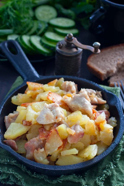 Patatas fritas con pollo en una sartén de hierro fundido, enfoque selectivo — Foto de Stock