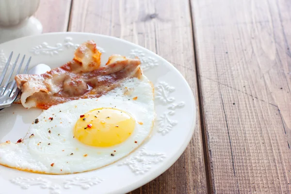 Traditionelles englisches Frühstück aus Spiegeleiern mit Speck auf einem Holztisch, waagerecht, Platz für Text — Stockfoto