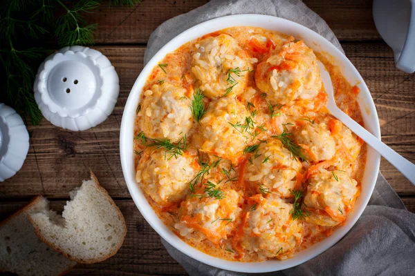 Albóndigas con arroz, erizos, en salsa de crema agria de tomate en una mesa de madera, vista superior, horizontal — Foto de Stock