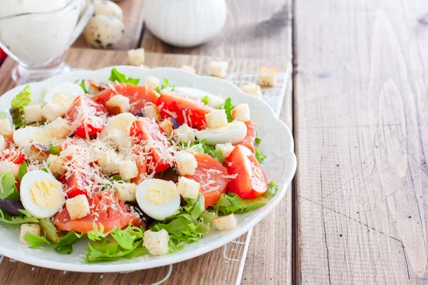 Caesar-Salat mit gesalzenem Lachs auf weißem Teller, waagerecht, Kopierraum — Stockfoto