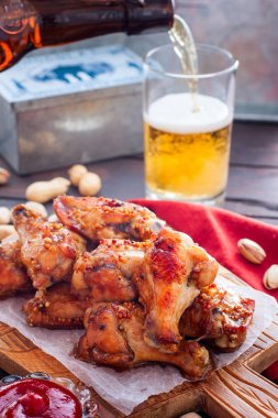 Ahşap bir tahta üzerinde pişmiş bira kanatları, seçici odak