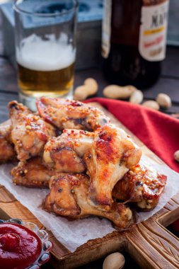Ahşap bir tahta üzerinde pişmiş bira kanatları, seçici odak