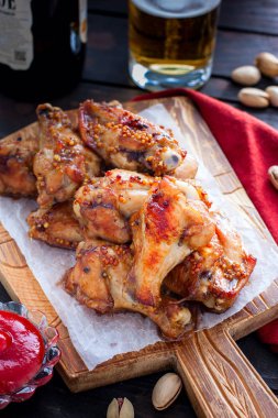 Ahşap bir tahta üzerinde pişmiş bira kanatları, seçici odak