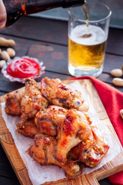 Ahşap bir tahta üzerinde pişmiş bira kanatları, seçici odak