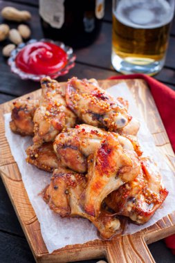 Ahşap bir tahta üzerinde pişmiş bira kanatları, seçici odak