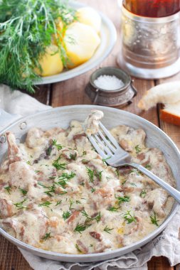 Ahşap bir masada bir tavada ekşi krema soslu Orman mantar, seçici odak