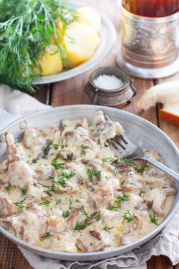 Ahşap bir masada bir tavada ekşi krema soslu Orman mantar, seçici odak