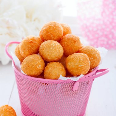 Beyaz bir masa, kare üzerinde pembe bir sepet içinde Peynir topları