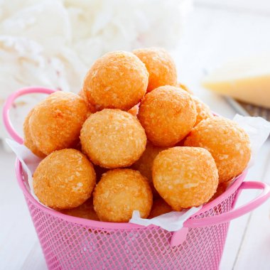 Beyaz bir masa, kare üzerinde pembe bir sepet içinde Peynir topları