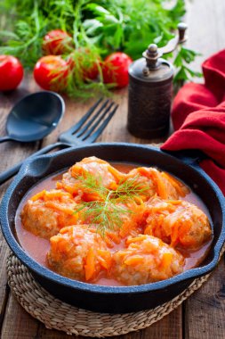 Domates soslu pilavlı köfte ve siyah dökme demir tavada sebzeler, seçici odak