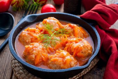 Ahşap bir masa üzerinde dökme demir tava domates sosu pirinç ile Köfte, yatay