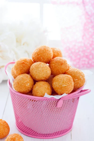 Deep fried cheese balls in a pink basket, selective focus