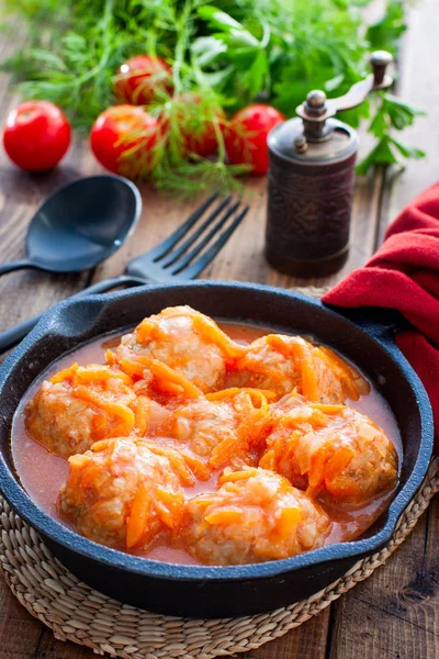 Domates soslu pilavlı köfte ve siyah dökme demir tavada sebzeler, seçici odak