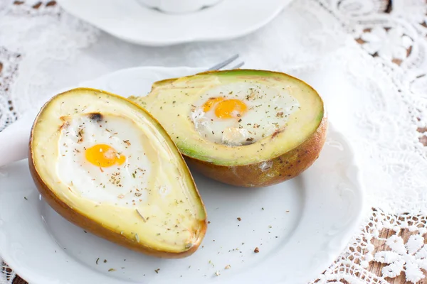 Gebacken mit Avocado-Ei zum Frühstück auf einem weißen Teller, horizontal — Stockfoto