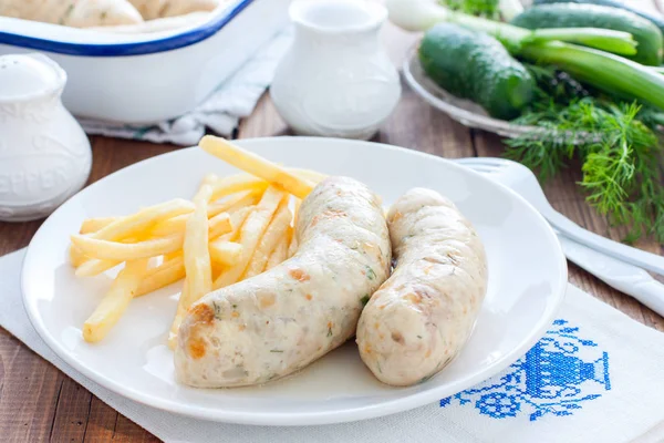 Домашние колбаски с курицей и картошкой фри на белой тарелке, горизонтальная — стоковое фото