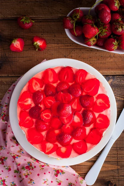 Cheesecake utan bakning med jordgubbar på ett träbord, uppifrån, selektiv fokus — Stockfoto