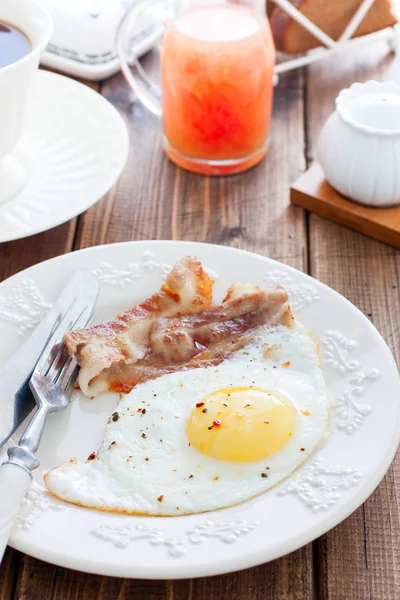 Colazione di uova fritte con pancetta su un tavolo di legno, focalizzazione selettiva — Foto Stock