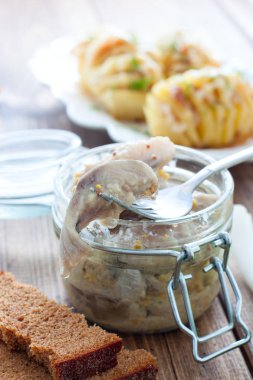 Ringa balığı bir cam kavanozda hardal parçaları marine, seçici odak