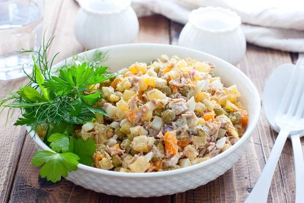 Ensalada Olivier con carne hervida y carne sobre una mesa de madera, horizontal — Foto de Stock