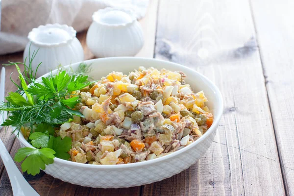 Ensalada Olivier con carne hervida y carne sobre una mesa de madera, horizontal, lugar para texto — Foto de Stock