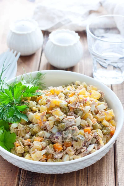 Ensalada tradicional rusa Olivier con verduras y carne. Ensalada de invierno Ensalada casera Olivier con carne hervida y carne en una mesa de madera, enfoque selectivo — Foto de Stock